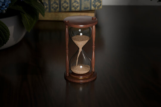 Vintage wooden hourglass on a dark table