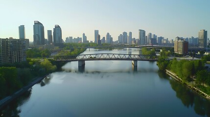 Naklejka premium Aerial view of a contemporary bridge with calm water beneath and surrounding cityscape.