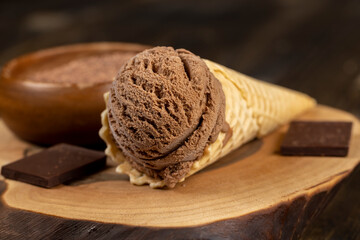 chocolate ice cream in a cone on a board
