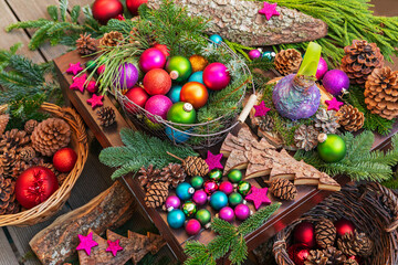 Various Christmas decoration items including baubles, pine cones, and fir tree branches.