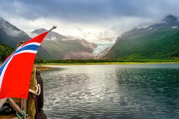 Scenic view of Holandsfjord with Norwegian flag at ferry terminal in Holandsvik, Norway