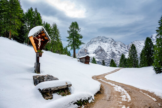 Snowy landscape in the South Tyrol Dolomites with a wooden cross and mountain views