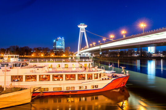 Illuminated view of a ship and the Slovak National Uprising Bridge in Bratislava at night