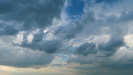 Obraz premium Dramatic sky with gray dark clouds before rain. Powerful cumulus clouds with a dark base. Timelapse.