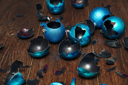 Blue broken Christmas ornaments on a wooden floor