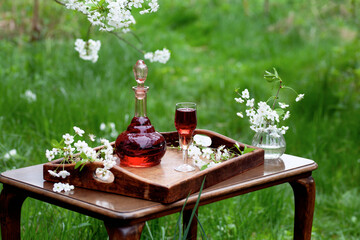 Cherry liqueur in vintage carafe -  homemade fruit alcoholic drink in the spring garden.