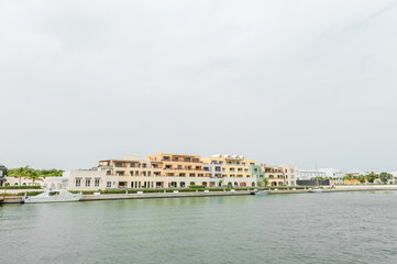 Punta Cana Architecture with port and Private Yacht. Dominican Republic. Luxurious Waterfront Residences With Yacht Docked Alongside Lush Palm Trees