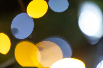A blurry picture captures a collection of bright lights shining in the darkness of the night sky,...