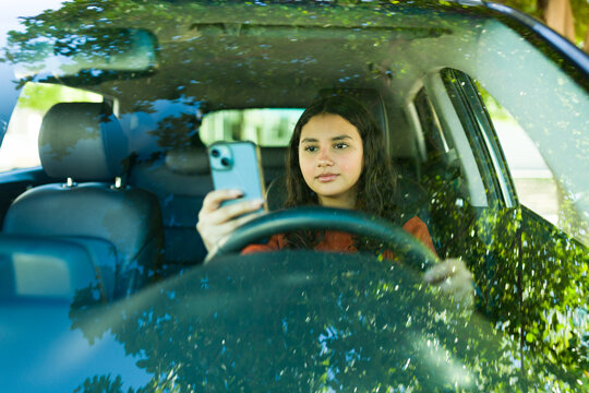 Distracted driving: teenager using phone behind the wheel, a risky and unlawful act
