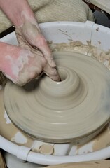 Working with clay at the first stage. The master teaches how to work with clay. Closeup of hands working on pottery wheel. profession and Hobbies: working on the Potter's wheel, molding a pitcher