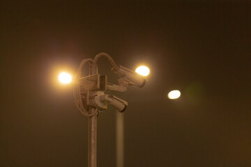 A slightly blurred and indistinct image showcasing a street light shining brightly against the...
