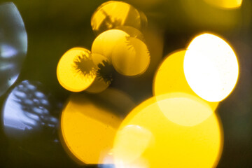 A somewhat blurry picture displaying a multitude of vibrant yellow lights contrasted against a...