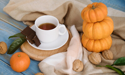 Autumn flat lay background. Pumpkins, apples, nuts,leaves, cups and sweater on wooden background.