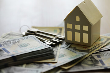Model of cardboard house with key and dollar bills. Building, loan, real estate, cost of housing or...