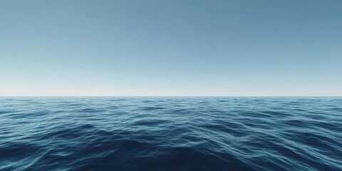 Fototapeta premium Calm, deep blue sea stretching to the horizon, with gentle waves and a clear, cloudless sky above, the upper half reserved for text.