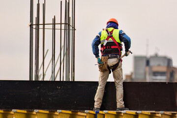 Worker with  safety belt build scaffolding at the construction  site