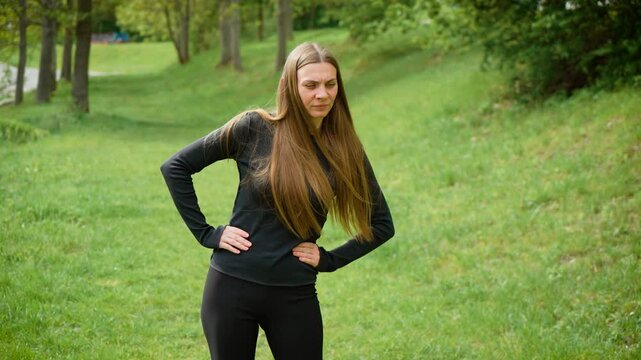 Young woman dancing, rotating hips outdoors. Female twirling waist while moving energetically in open air. Lady swaying and spinning gracefully outside