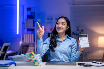 A woman is holding a calculator and pointing to the number 2