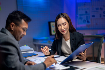 A man and a woman are sitting at a desk with a clipboard in front of them