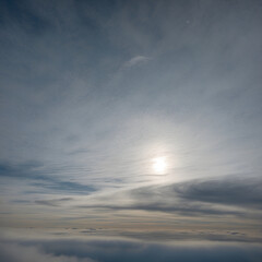 Fototapeta premium Soft sunlight filtering through thin clouds, creating a serene atmosphere in a muted sky, copy space