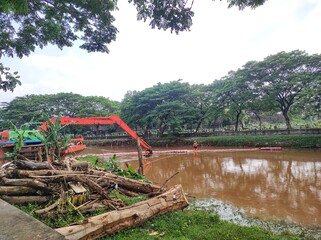 Workers clean the river from debris on the floating rubbish trapper. Jakarta. Indonesia.
