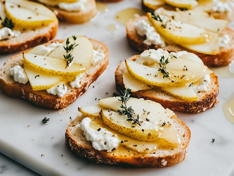 Gourmet crostini with fresh pear slices, creamy goat cheese, drizzled honey, and garnished with thyme on crispy toasted bread. A perfect appetizer for elegant gatherings