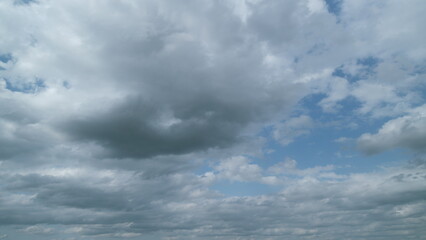Blue summer sky with thick thunderstorm clouds moving across. Dark grey storm clouds. Timelapse.