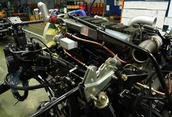 Fototapeta premium Truck production line. Workshop production of Heavy duty trucks. Trucks Manufacture. Assembly line of truck factory. Heavy duty truck plant. Frame, Wheel chassis, air suspension, air springs. Engine