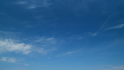 Floating fluffy cirrus clouds. Beautiful sunny blue sky with wispy smoky white. Timelapse.