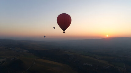 Fototapeta premium A hot air balloon floating above the countryside, with other balloons in the distance and a clear sky. Hot air balloon over countryside.