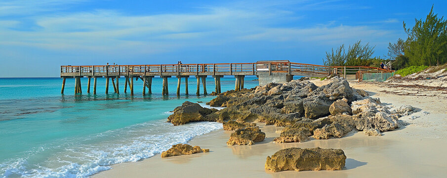 Serene beachside pier with clear waters and rocky shoreline