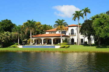 Obraz premium Luxurious waterfront mansion surrounded by lush greenery