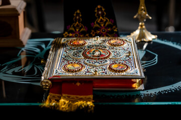 Ornate Religious Book with Iconography on Glass Table