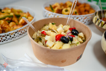 Delicious Potato Salad with Olives and Peppers in a Disposable Bowl