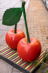Arrangement in front of the street shop in form of beautiful red cherries made of plastic,