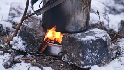 Metal Pot with Boiling Water on Improvised Paraffin Heater Campfire Stove during Hiking Trip