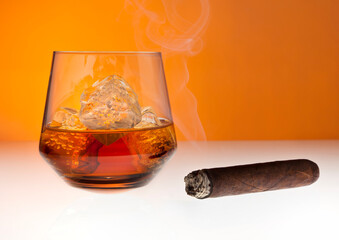 Glass of whiskey and smoking cigar