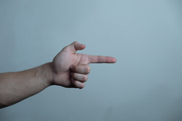 Male hand making a gesture like holding a gun, gun symbol or shooting a gun, isolated on background.