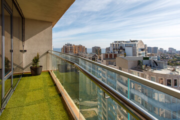 Panoramic view from the balcony with artificial grass and glass railing.