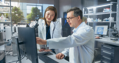 Two Scientists Discussing Latest Bioengineering Discoveries and Sharing Research Data on Vaccine...
