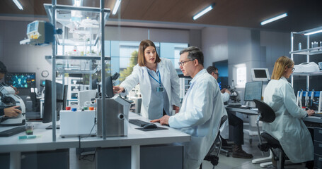 Two Scientists Discussing Latest Bioengineering Discoveries and Sharing Research Data on Vaccine Efficacy. Diverse Male and Female Colleagues Working in a Modern Medical Research Center