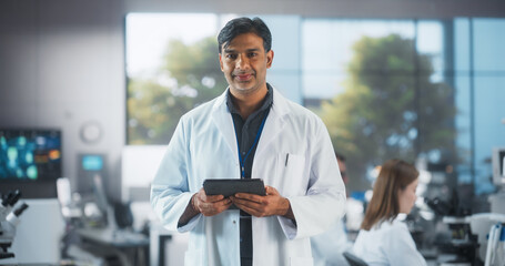 Medical Science Laboratory: Portrait of a Handsome Indian Male Scientist Wearing a White Medical...