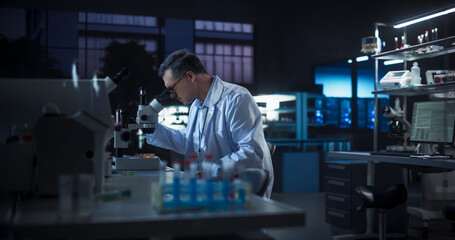 Molecular Biology Research Scientist Looking at a DNA Sample Under a Microscope in an Applied...