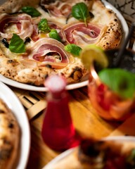 Gourmet pizza with prosciutto and basil.