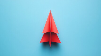 Fototapeta premium Red paper airplane flying on blue background symbolizing leadership and innovation