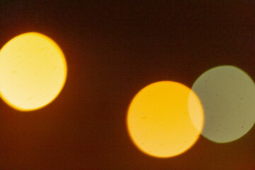This image features a blurry depiction of two distinct yellow circles set against a contrasting...