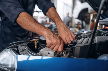 Blue automobile, working. Close up view of mechanic in car service station