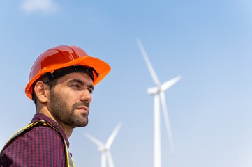 Male man engineer inspection posing check control wind power machine in out door wind energy factory. Young man technician professional worker check wind power machine for maintenance turbine