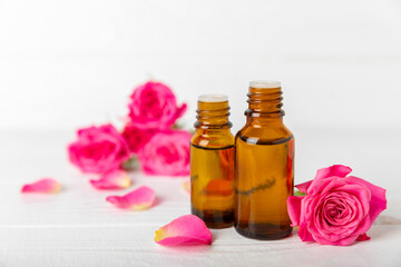 Rose essential oil on a textured background.Roses and a bottle of rose perfumed water.Aromatherapy treatment. Beauty concept. Spa procedure.Natural organic oil.Anti-stress,detox relax.Place for text