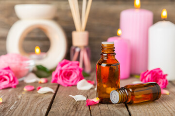 Rose essential oil on a textured background.Roses and a bottle of rose perfumed water.Aromatherapy treatment. Beauty concept. Spa procedure.Natural organic oil.Anti-stress,detox relax.Place for text